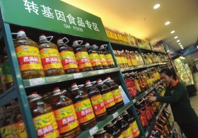 1月2日，蘭州某超市工作人員在轉(zhuǎn)基因食品專柜擺放食用油。　圖/新華社